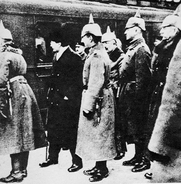 Photographie de Léon Trotsky, en habit noir, entouré d'officiers allemands à Brest-Litovsk, fin 1917.